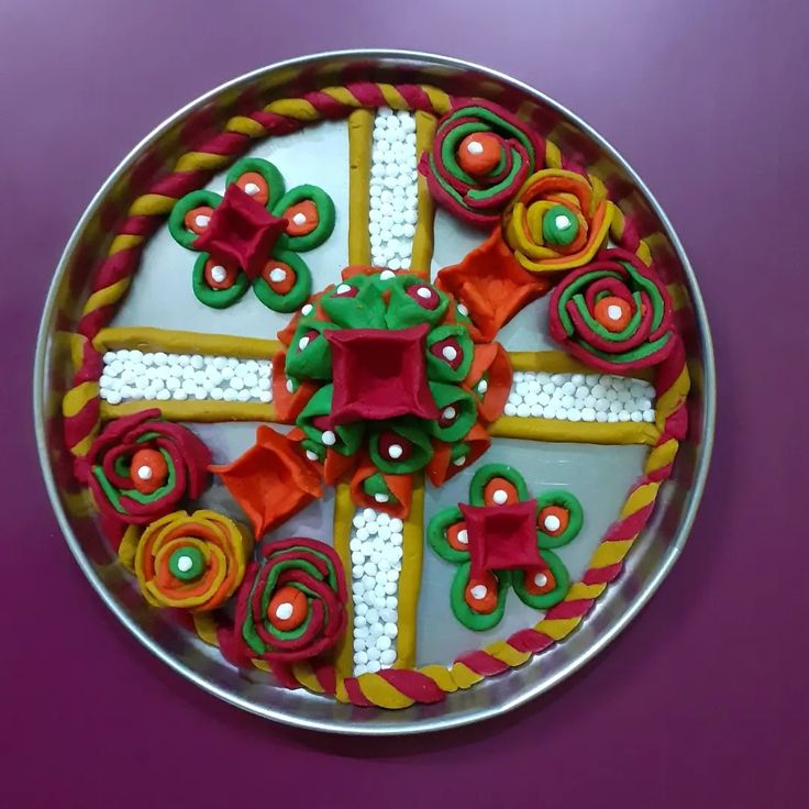 a metal plate topped with lots of colorful decorated cookies on top of a purple table