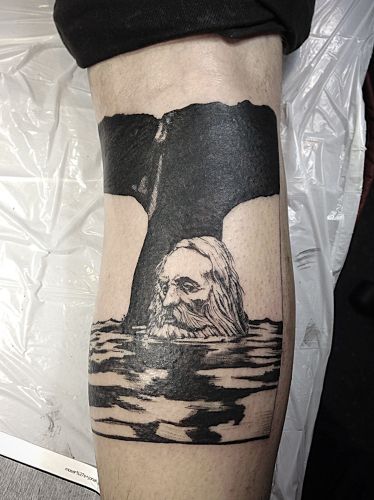 a man's leg with a black and white photo of a whale on it