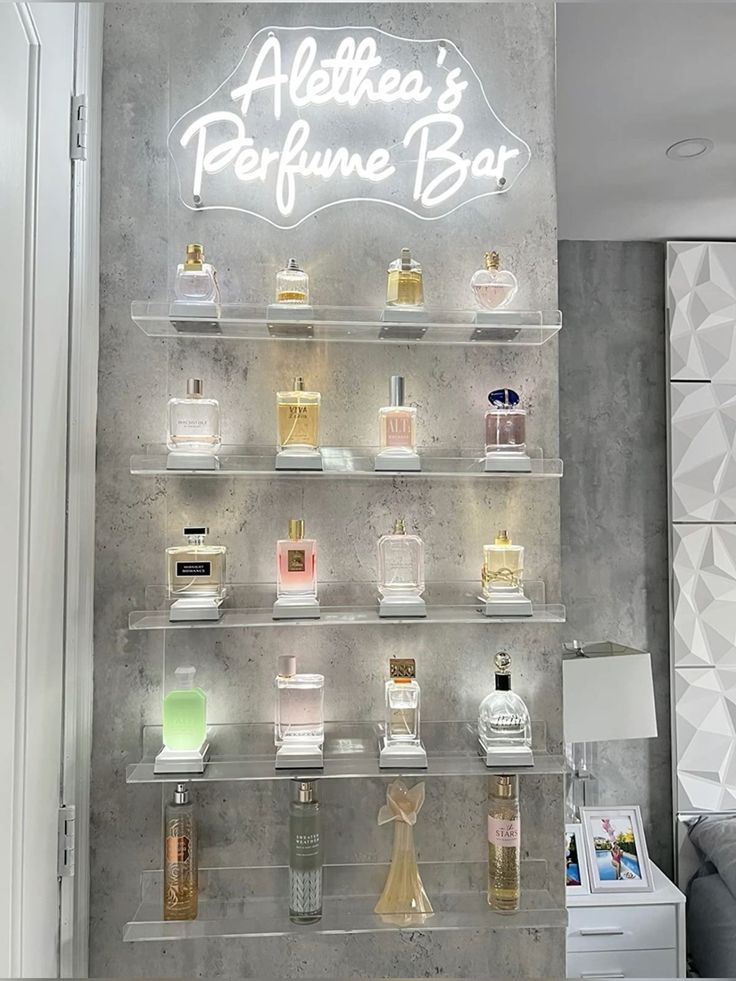 a display case filled with different types of perfumes on shelves next to a wall