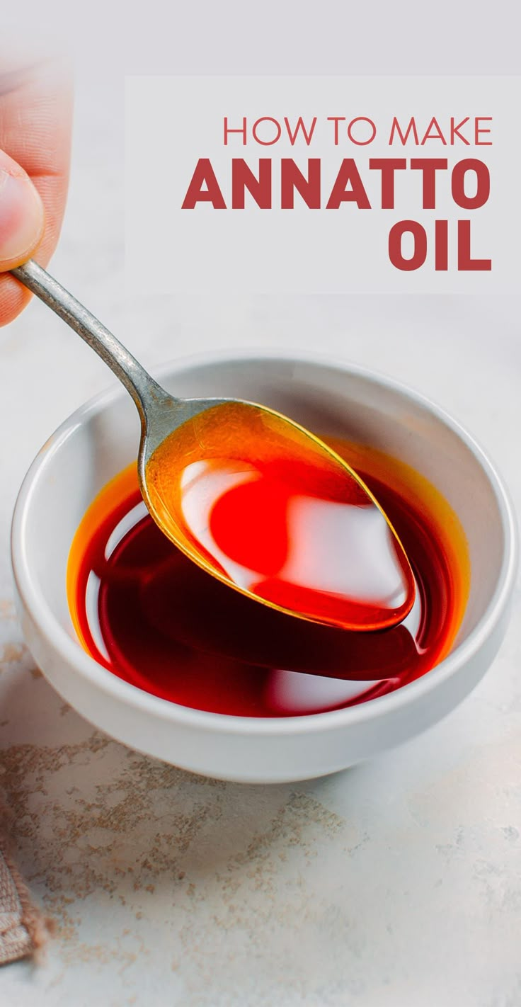 a spoon in a white bowl filled with an orange and red liquid that says how to make annatto oil