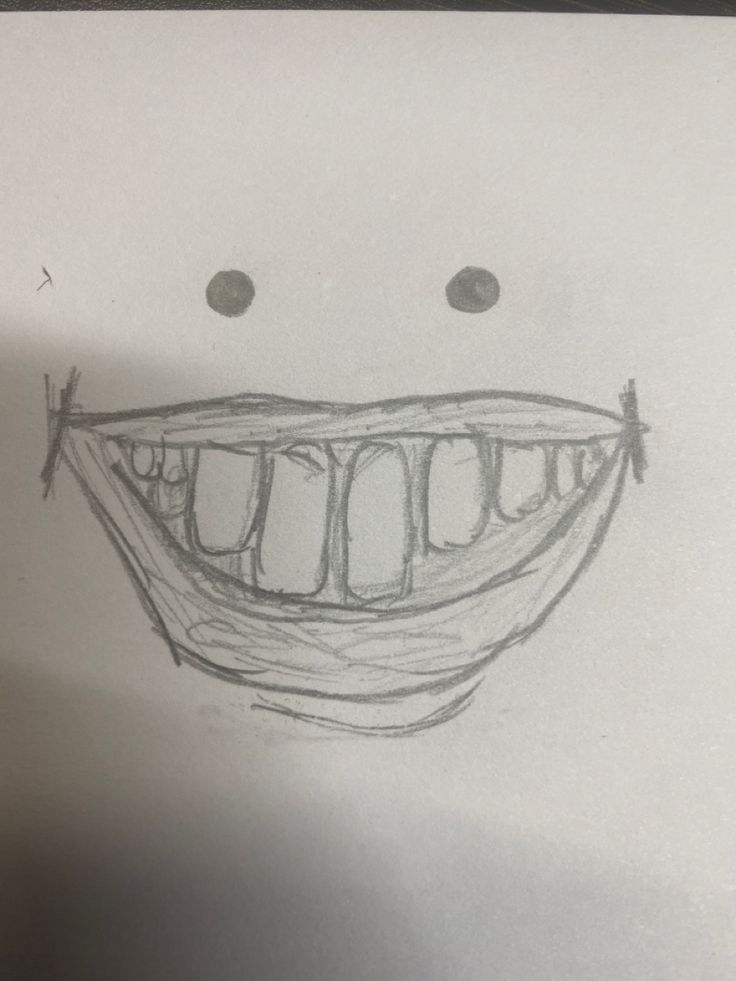 a pencil drawing of a smiling face with two eyes and one mouth is drawn on paper