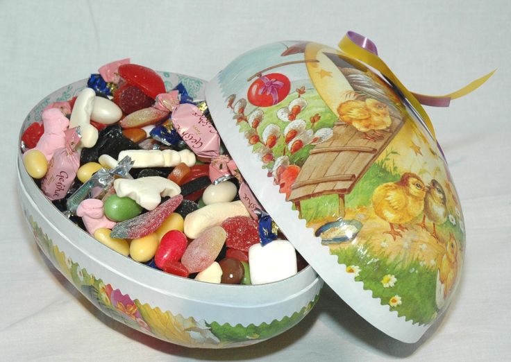 two tins filled with candy sitting on top of a white counter next to each other