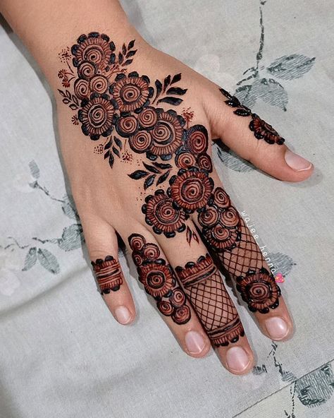 a woman's hand with henna tattoos and flowers on the palm, which is decorated