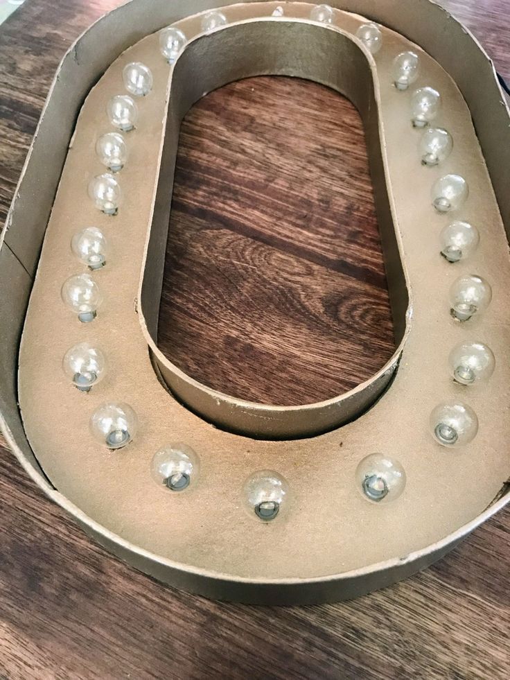 a metal horseshoe with pearls on it sitting on a wooden table