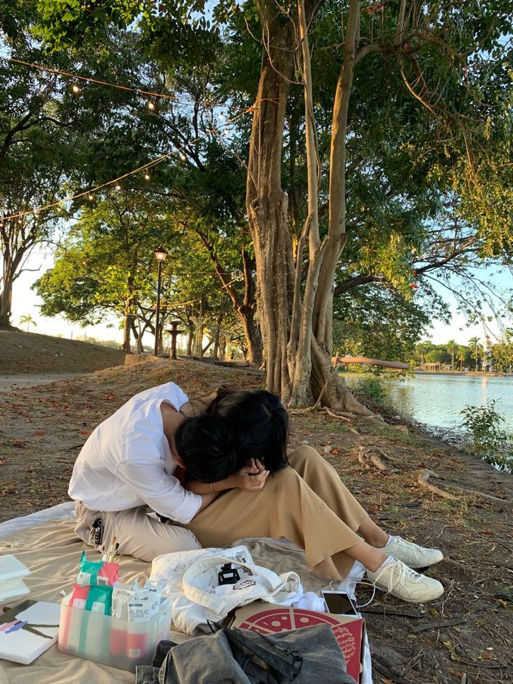 a woman laying on the ground next to some trees