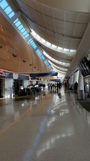 people are walking through an airport terminal with their luggage and baggage carousels in the background