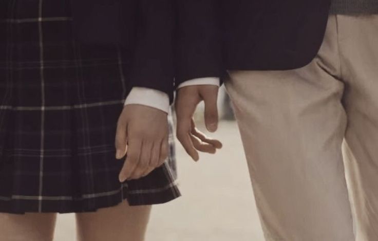 two people standing next to each other holding hands