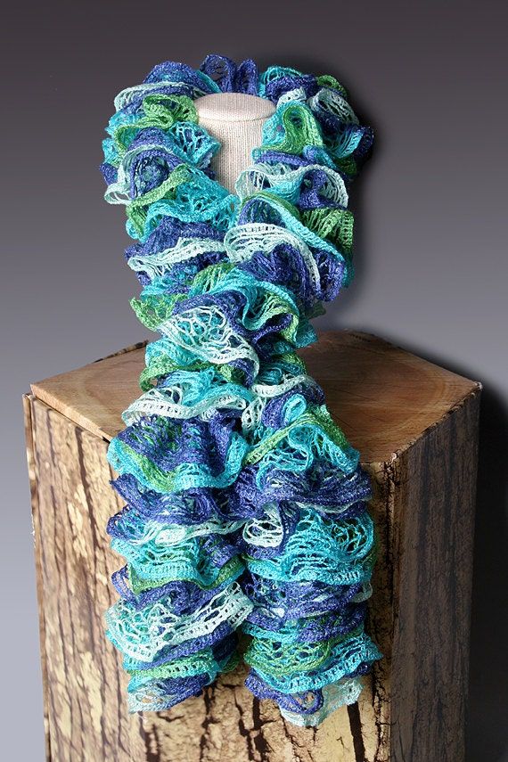 a blue and green scarf sitting on top of a wooden block