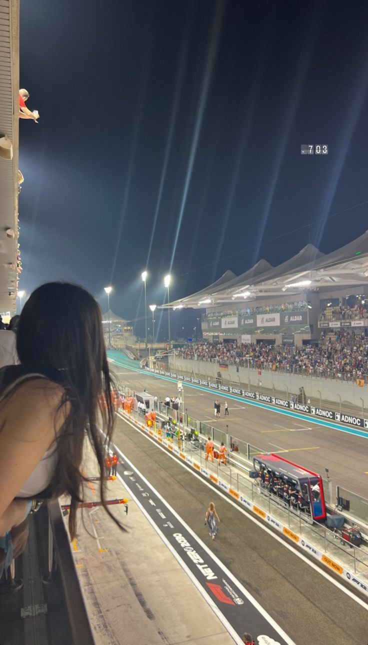 a woman looking out the window at a race track