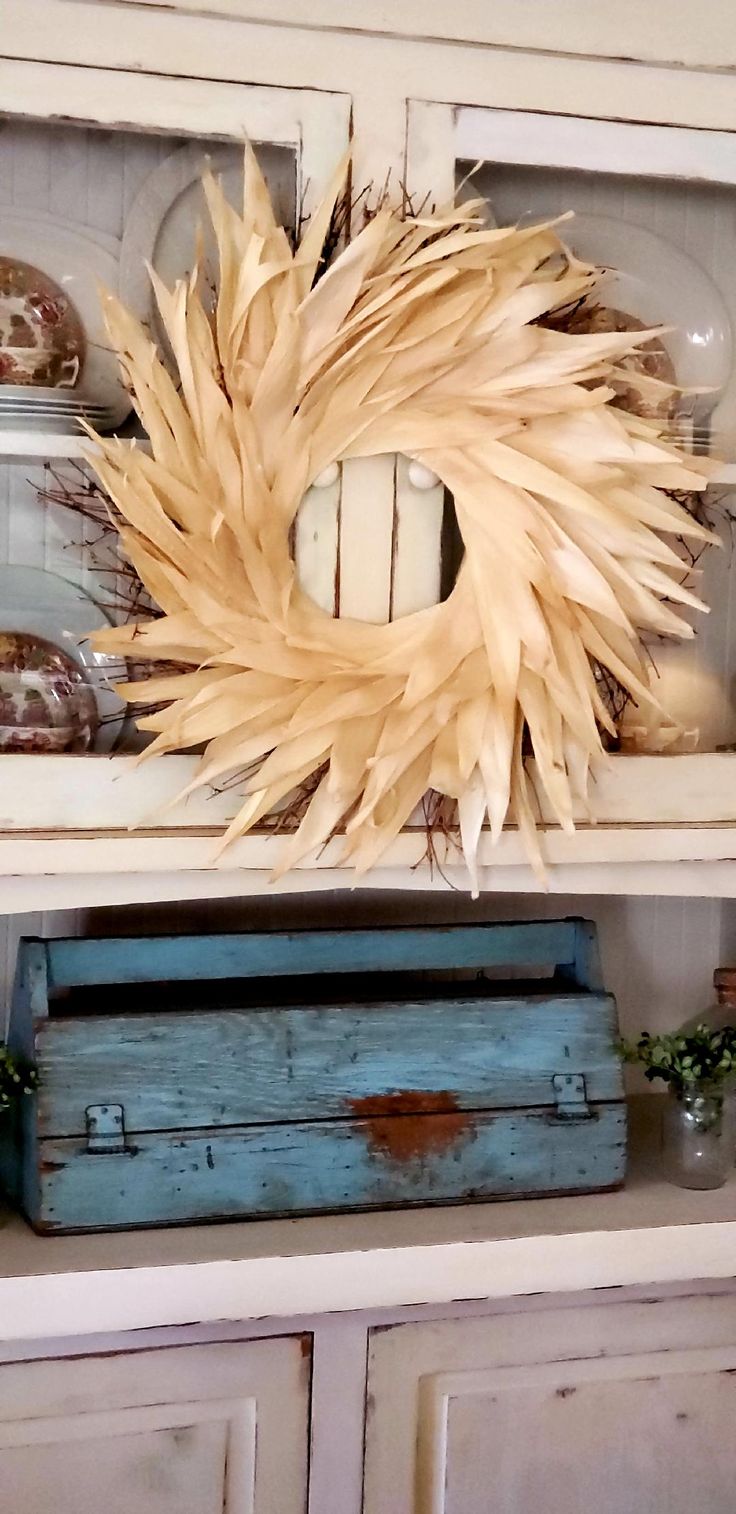 a corn wreath on top of a hutch