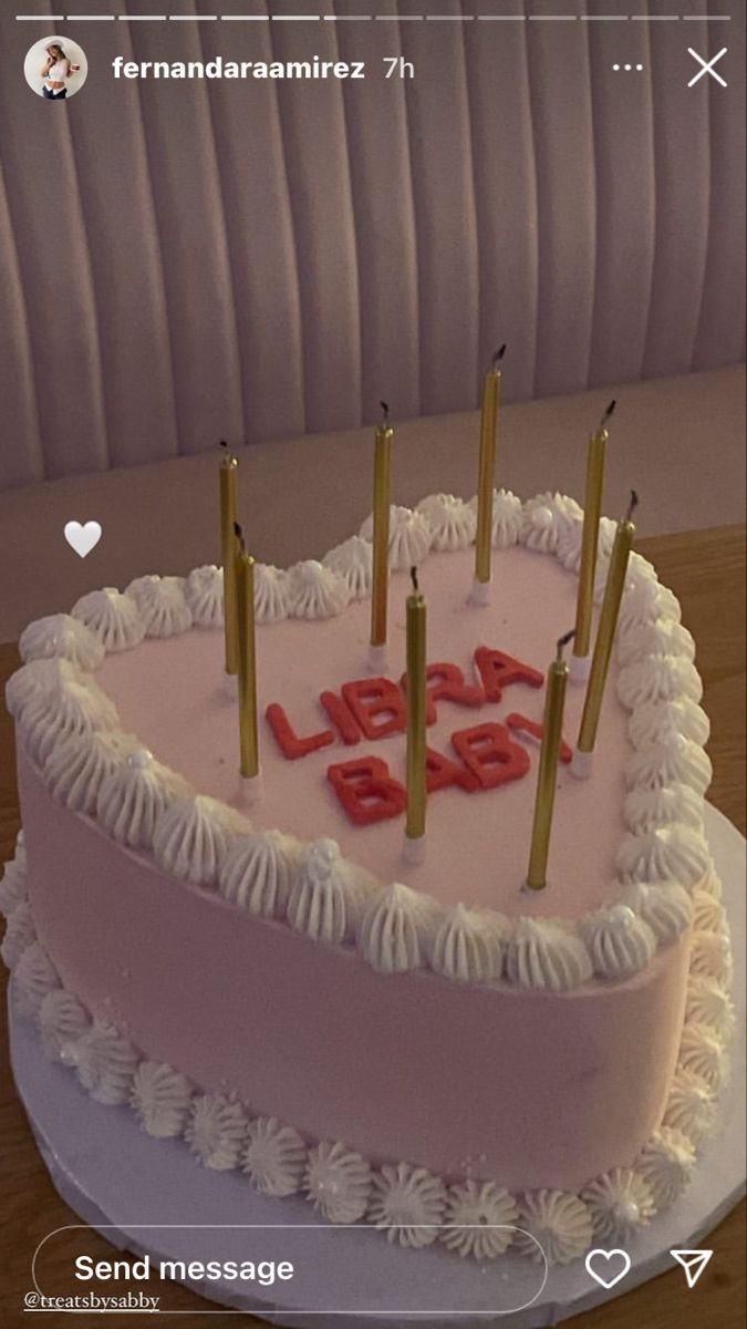 a heart shaped birthday cake with candles on it