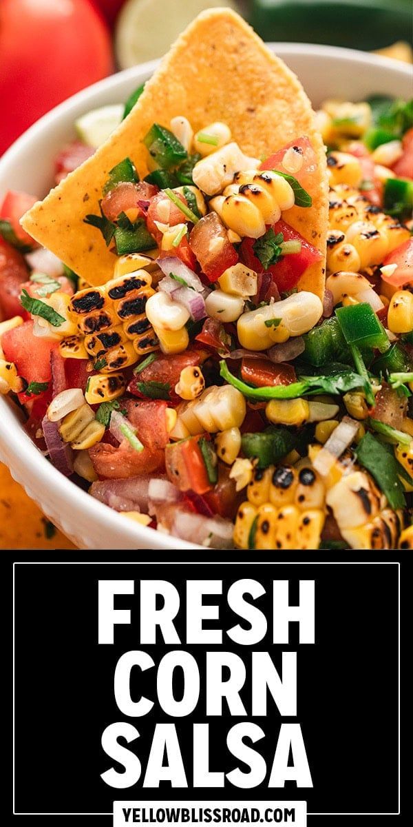 fresh corn salsa in a white bowl with tortilla chips and tomatoes on the side