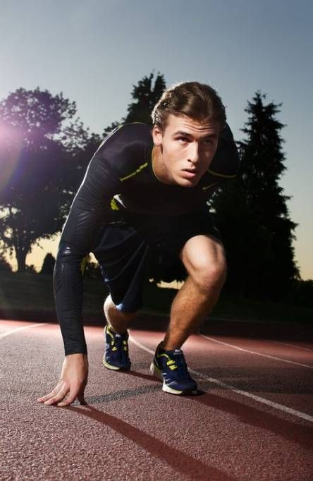 a man in black and yellow running on a track