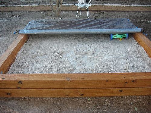 an empty bed frame sitting in the sand