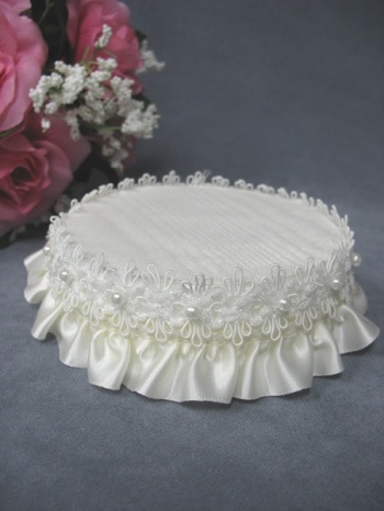 a white wedding cake sitting on top of a table next to pink roses and baby's breath