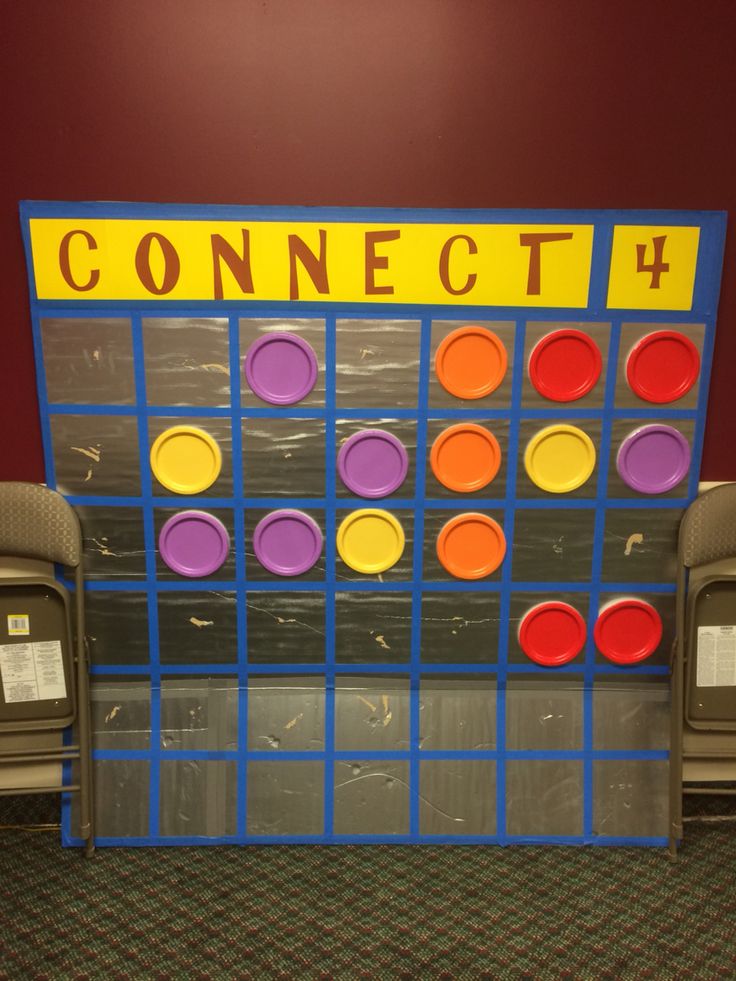 a game set up in the middle of a room with two chairs and a sign that says connect 4