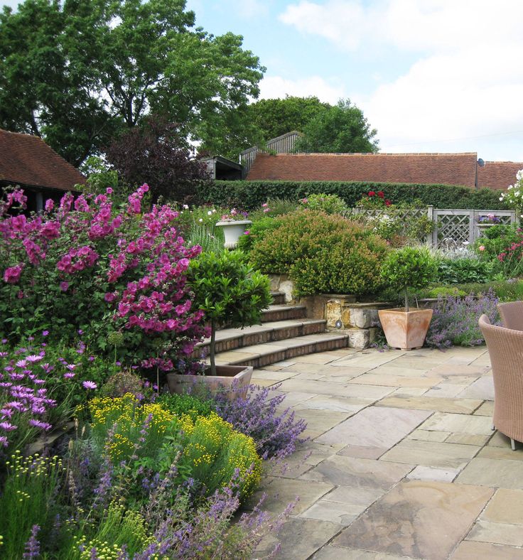 an outdoor patio with seating and flowers in the foreground