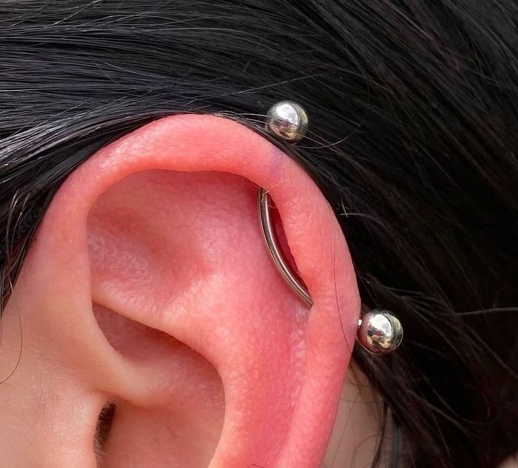 a close up of a person's ear with two piercings on the side