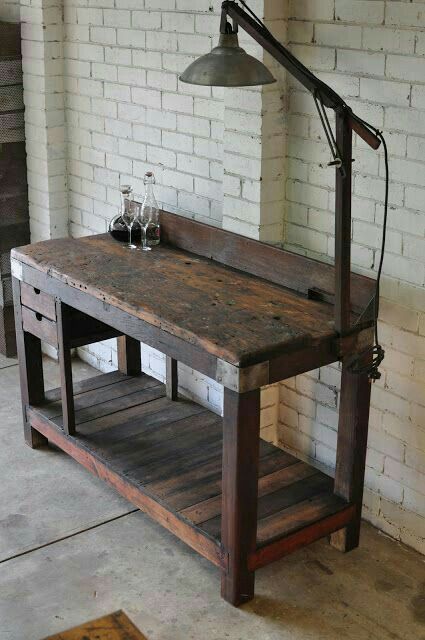 an old wooden table with a lamp on top