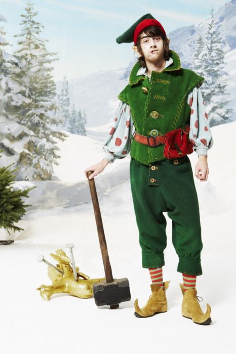 a man dressed in green and red holding a shovel