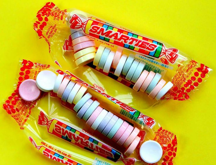 three small candy bars sitting next to each other on a yellow surface with red, white and blue designs