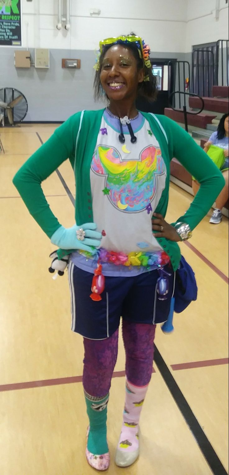 a woman standing in a gym with her hands on her hips and wearing colorful tights