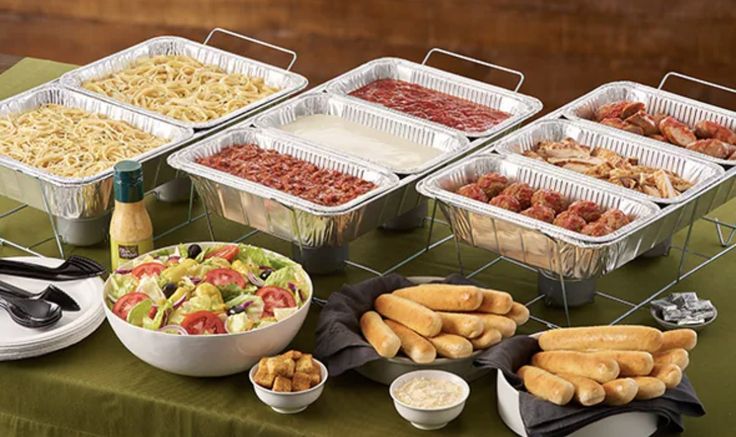 an assortment of food is displayed on a table with plates and bowls in front of it