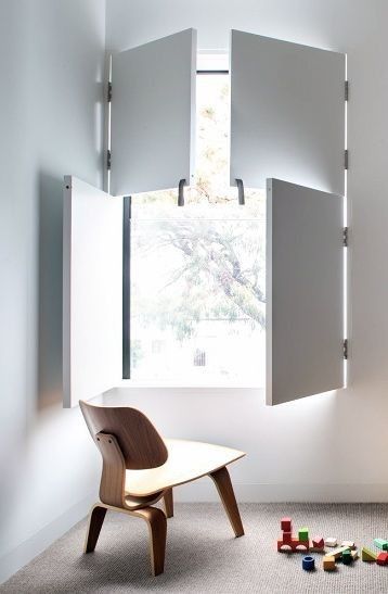 an empty room with a chair, window and toys on the floor in front of it