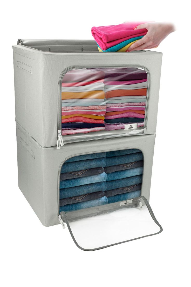 a person holding a cloth dispenser in front of a stack of folded clothes