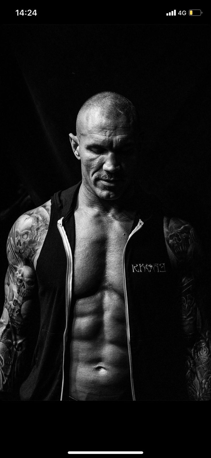 a black and white photo of a man with tattoos on his arm, shirtless torso