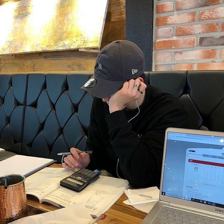 a man sitting at a table in front of a laptop computer with headphones on