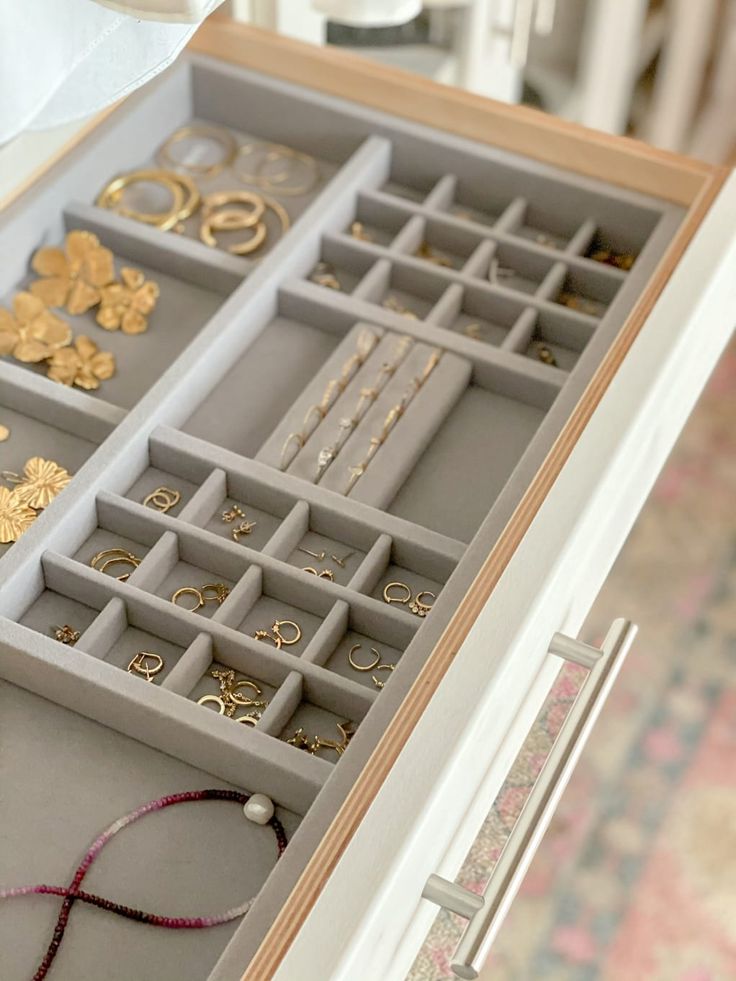 an open drawer with jewelry inside of it