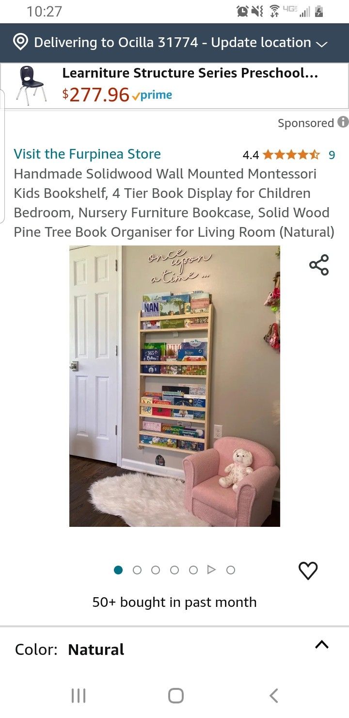 a pink chair sitting in front of a book shelf on top of a wooden floor