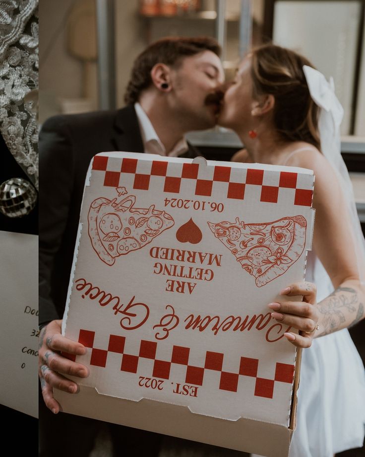 a bride and groom kissing in front of a sign