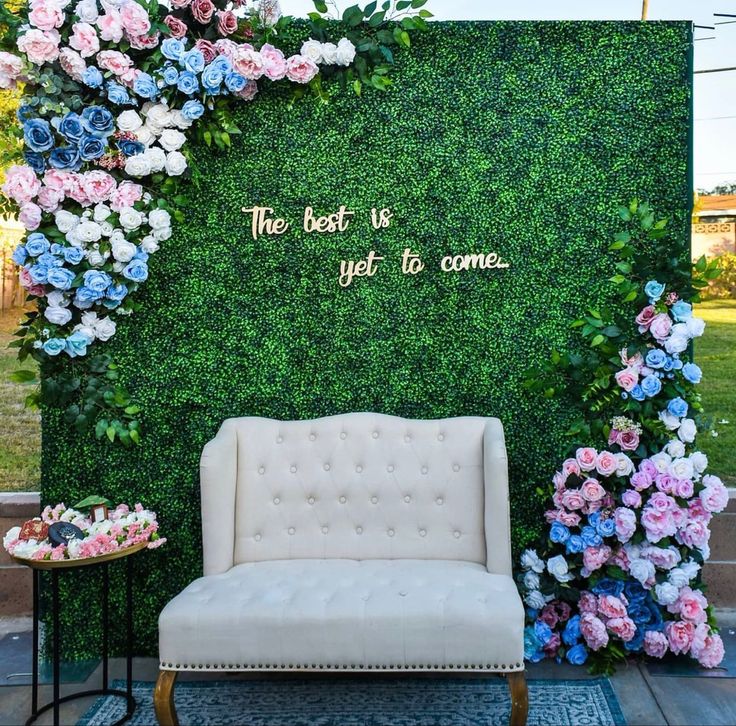 a white chair sitting in front of a green wall with flowers on it and the words, there best is yet to come