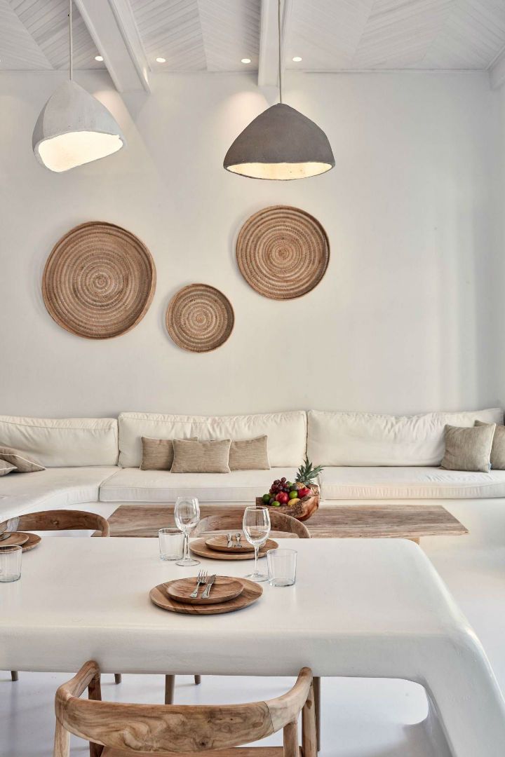 a living room with white furniture and two circular artwork on the wall above the table