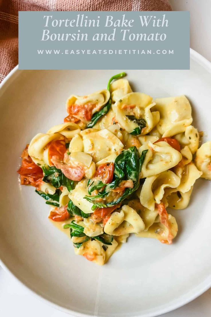 tortellini bake with bourssin and tomato on a white plate next to a pink towel