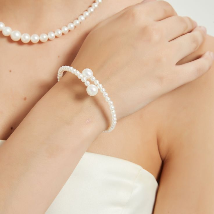 Experience elegance redefined with our "Eternal Embrace" White Freshwater Pearl Bracelet. Two large pearls gracefully frame the open closure, forming a captivating large circle that symbolizes unity and endless beauty. The design's simplicity accentuates the pearls' natural allure, making it a versatile piece suitable for both casual and formal occasions. A classic with a contemporary twist, this bracelet is a timeless addition to any jewelry collection. Pearl size 5-7mm Note: Our jewelry is han Formal Pearl White Bracelet With Pearl Chain, Formal Pearl White Pearl Bracelet With Pearl Chain, Formal Pearl White Pearl Chain Bracelet, Formal Pearl Bracelet With Pearl Charm, Elegant Pearl Bracelet For Formal Occasions, Pearl Bracelet With Pearl Charm For Formal Occasions, Elegant Pearl Drop Bracelet For Party, Formal White Pearl Embellished Bracelets, Formal White Pearl Bracelets