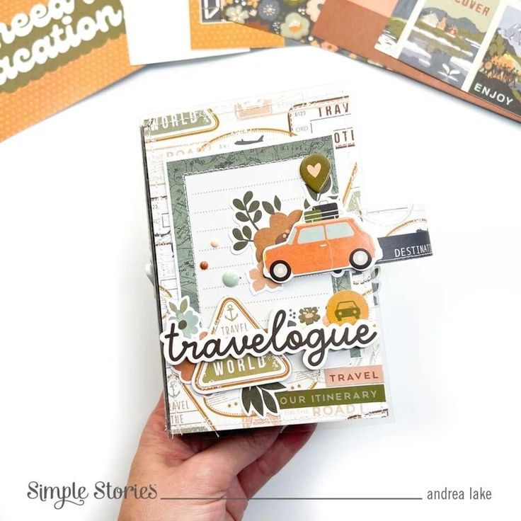 someone holding up a small card with the words travelogue on it and an orange car