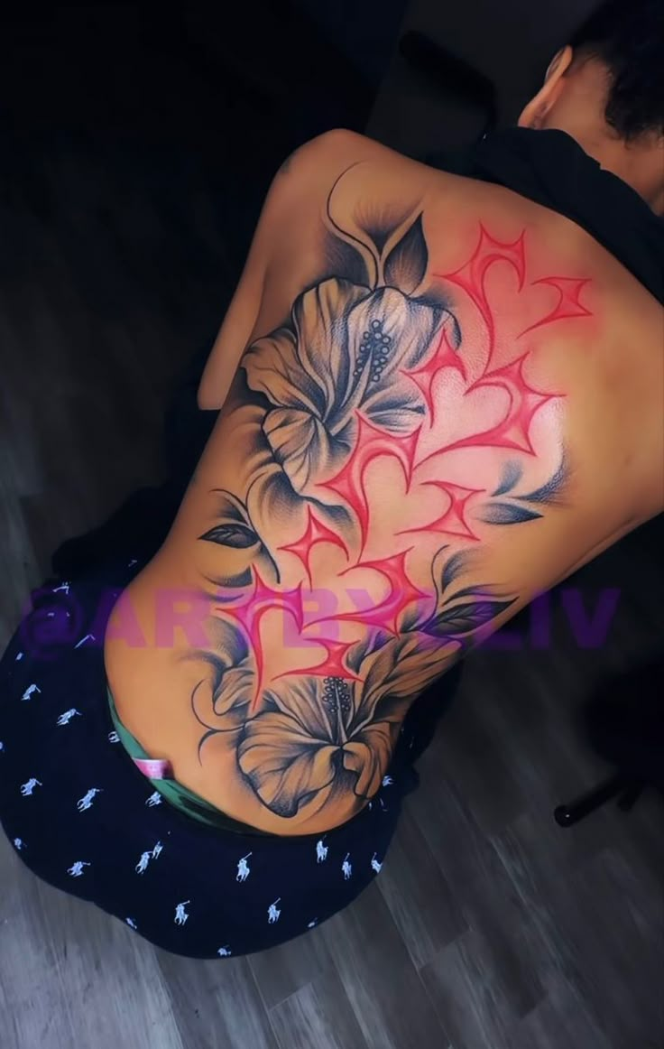 the back of a woman's body with flowers painted on her stomach and chest