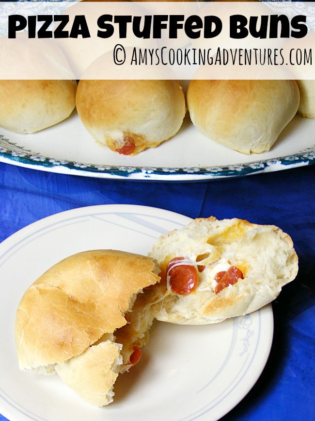 two plates filled with pizza stuffed buns on top of a blue tablecloth covered table