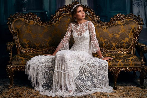 a woman sitting on top of a couch wearing a white dress