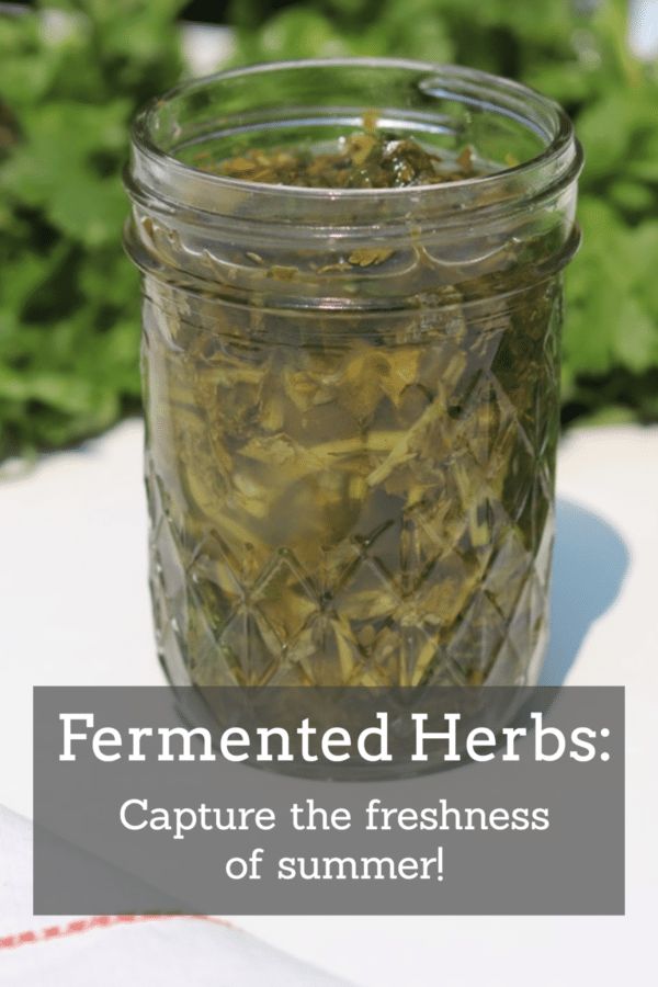 a jar filled with green herbs sitting on top of a table