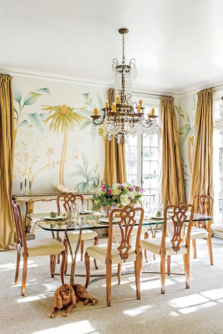 a dining room table with chairs and a chandelier hanging from it's ceiling