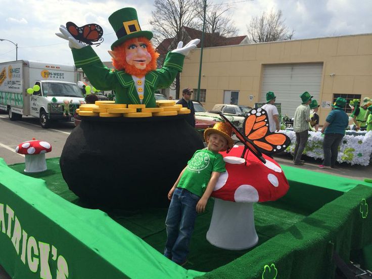 a young boy standing in front of a float with a lepreti man on it