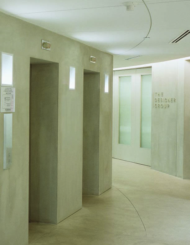 an empty room with three urinals in the middle and signs on the walls