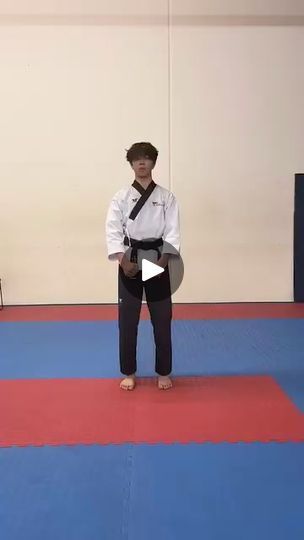 a man standing on top of a blue and red mat next to another person in a white shirt