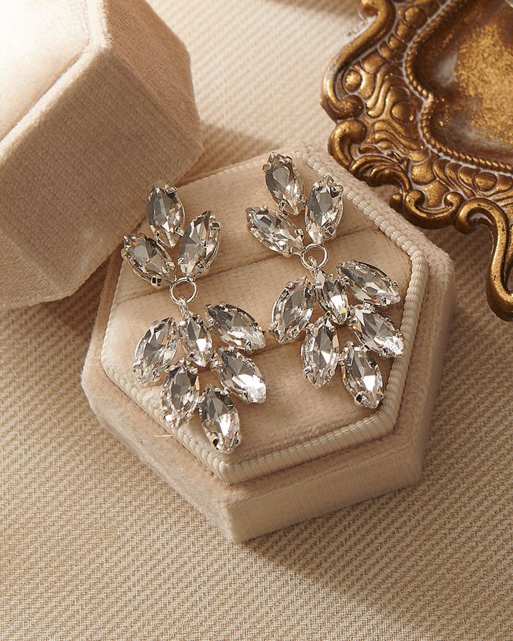 Add both beauty and sparkle to your wedding day look with our Angelina Wedding Earrings. Crafted with marquise shaped crystals in a floral leaf design, these earrings will become a forever favorite. Crystal gemstones 1.5" length x 0.5" width Hypoallergenic, lead-free & nickel-free Shown with Monica Comb, sold separately. Style #4300 Dazzling Crystal Earrings With Sparkling Stones, Sparkling Crystal Earrings, Dazzling Diamond White Crystal Earrings With Sparkling Stones, Dazzling Diamond White Earrings With Sparkling Stones, Dazzling Crystal Diamond Earrings With Sparkling Stones, Dazzling Crystal Diamond Earrings, Sparkling Diamond Drop Crystal Earrings, Elegant Diamond White Crystal Earrings, Diamond Crystal Drop Earrings With Sparkling Stones