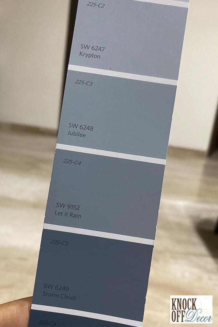 a person holding up a gray paint swatch