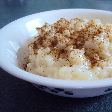 a bowl filled with mashed potatoes on top of a blue tablecloth covered table